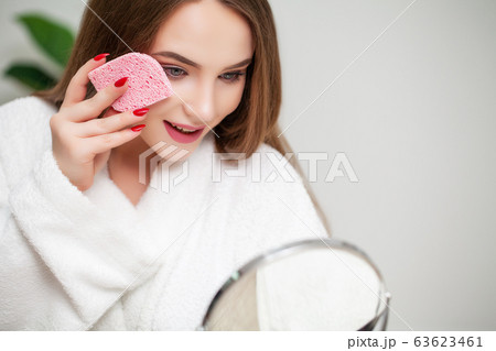 Pretty girl wipes the face after taking a shower sponge Pretty girl wipes the face after taking a shower sponge 63623461