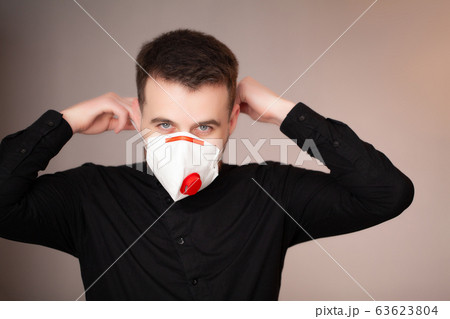 Man working in the office wearing a mask for protection from coronavirus. 63623804