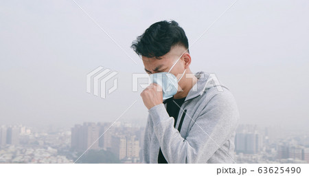 man coughs and wears mask 63625490
