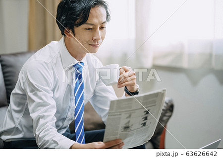 新聞を読むビジネスマンの写真素材