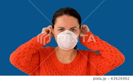 Woman putting on surgical mask for corona virus prevention 63626902