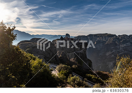 Aerial view of monastery Trinity and breathtaking pictures of valley and landmark canyon of Meteora at sunset, Kalambaka, Greece, shadows, twisted road, bridge, Mountains as columns 63630376