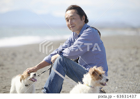 シニア男性 アクティブ 海 愛犬の写真素材