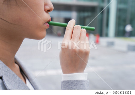 電子タバコを吸う若いビジネスウーマン 63631831