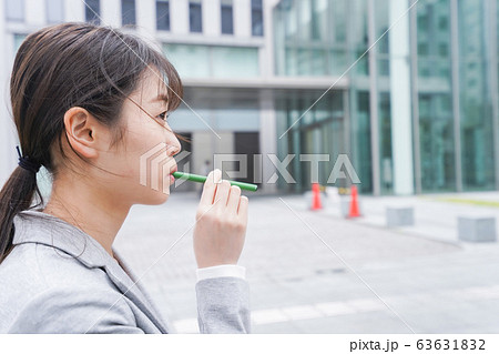 電子タバコを吸う若いビジネスウーマン 63631832