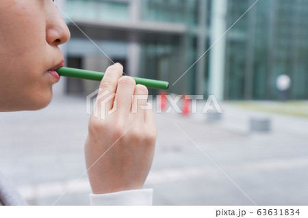 電子タバコを吸う若いビジネスウーマン 63631834