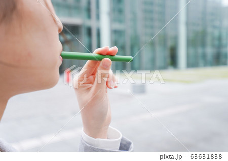 電子タバコを吸う若いビジネスウーマン 63631838