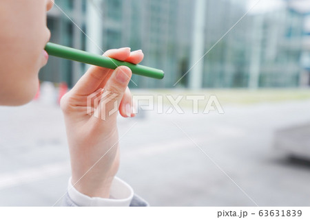 電子タバコを吸う若いビジネスウーマン 63631839