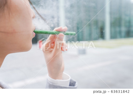 電子タバコを吸う若いビジネスウーマン 63631842