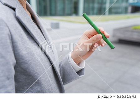 電子タバコを吸う若いビジネスウーマン 63631843