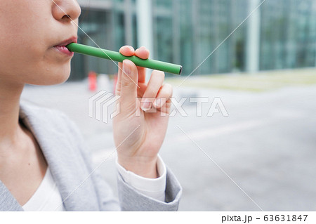 電子タバコを吸う若いビジネスウーマン 63631847