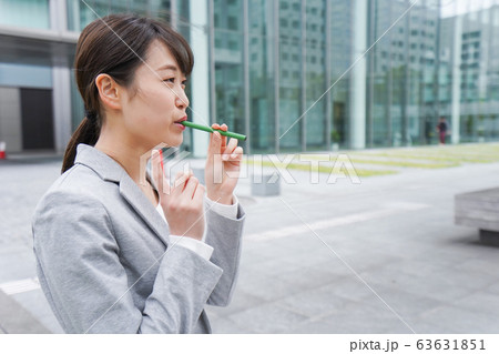 電子タバコを吸う若いビジネスウーマン 63631851