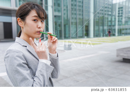 電子タバコを吸う若いビジネスウーマン 電子タバコを吸う若いビジネスウーマン 63631855