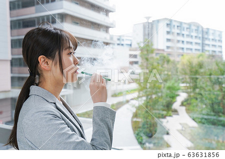 電子タバコを吸う若いビジネスウーマン 63631856