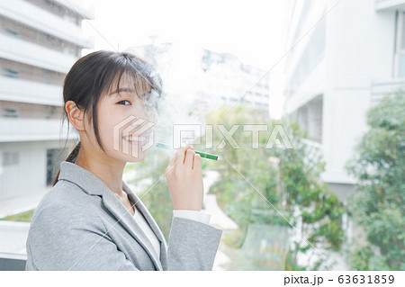 電子タバコを吸う若いビジネスウーマン 63631859
