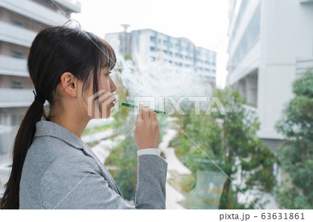 電子タバコを吸う若いビジネスウーマン 63631861