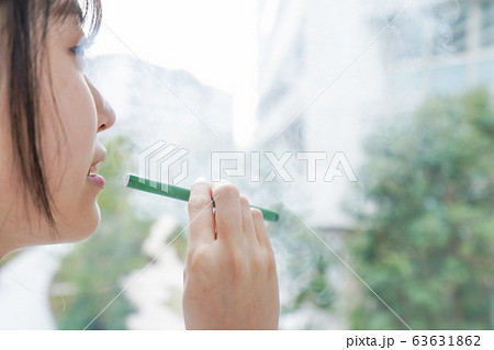 電子タバコを吸う若いビジネスウーマン 63631862