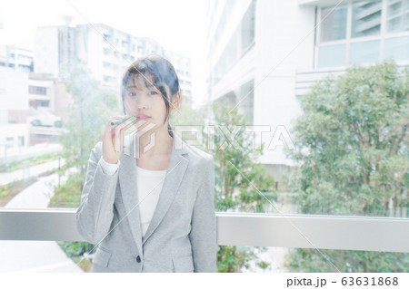 電子タバコを吸う若いビジネスウーマン 63631868