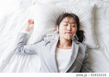 仕事中に仮眠を取る若いビジネスウーマン 63632016