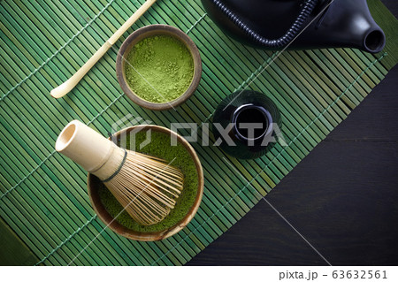 Matcha powder. Organic green matcha tea ceremony. Healthy drink. Traditional japanese drink on black wooden background Matcha powder. Organic green matcha tea ceremony. Healthy drink. Traditional japanese drink on black wooden background 63632561