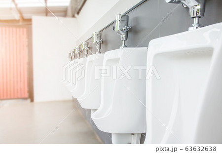 Men's room with white porcelain urinals in line. Men's room with white porcelain urinals in line. 63632638