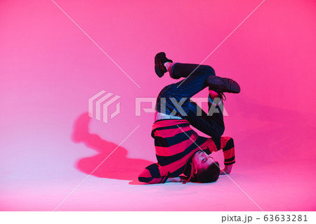 Young Man in a Jumper Dancing Contemporary Dance in Studio. Breakdancing. Dance School Poster. Copy Space. Battle competition announcement. Pink and Blue Background. Young Man in a Jumper Dancing Contemporary Dance in Studio. Breakdancing. Dance School Poster. Copy Space. Battle competition announcement. Pink and Blue Background. 63633281
