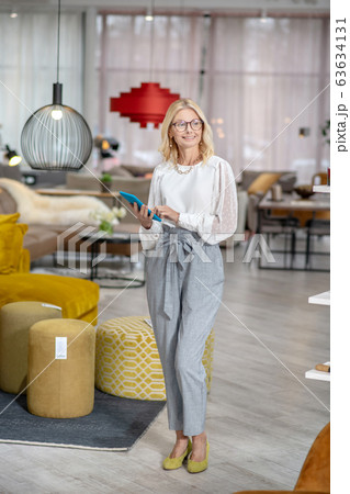 Woman in gray trousers with a tablet in hands. 63634131