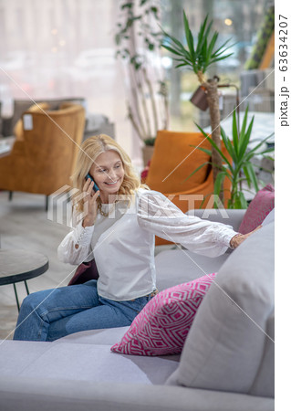Joyful woman sitting on the couch looking over him. 63634207