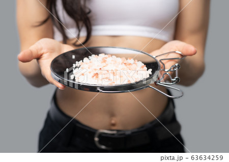 Girl in a white top holding a mirror in her hands 63634259
