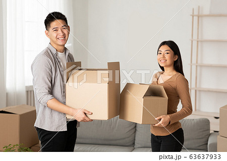 Happy asian family holding cardboard boxes in flat Happy asian family holding cardboard boxes in flat 63637933