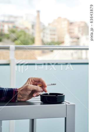 man in pajamas smoking in the balcony man in pajamas smoking in the balcony 63643879