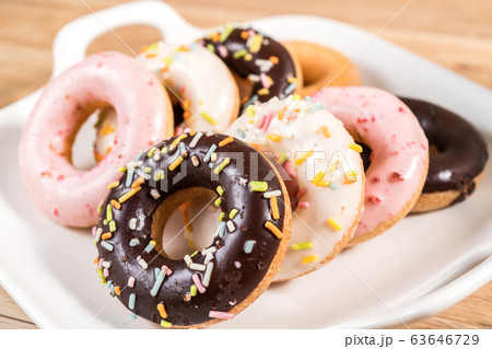 Donuts and coffee on wooden table. 63646729