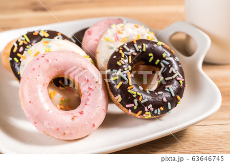 Donuts and coffee on wooden table. Donuts and coffee on wooden table. 63646745
