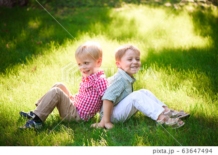 Two young boys walk and relax in the park. Two young boys walk and relax in the park. 63647494
