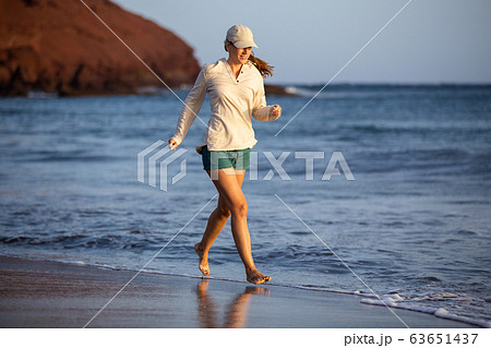 Young woman having fun at ocean beach on vacation Young woman having fun at ocean beach on vacation 63651437