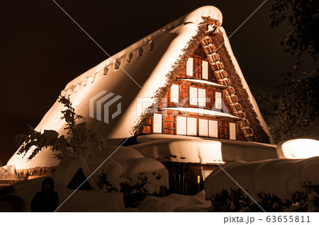 A vila de Shirakawa, um patrimônio mundial, com suas casas tradicionais com telhados em estilo gassho-zukuri a noite no inverno 63655811