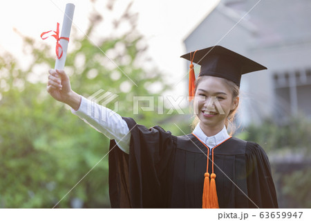 Women Student Graduate in cap and gown celebrating with certificate in hand and so proud 63659947