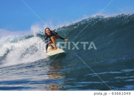 Female surfer on a wave Female surfer on a wave 63661049