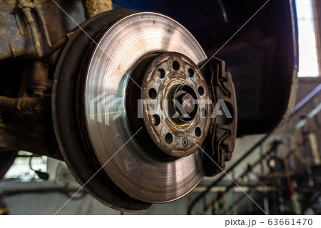 Car brake disc closeup on car service lifted for 63661470