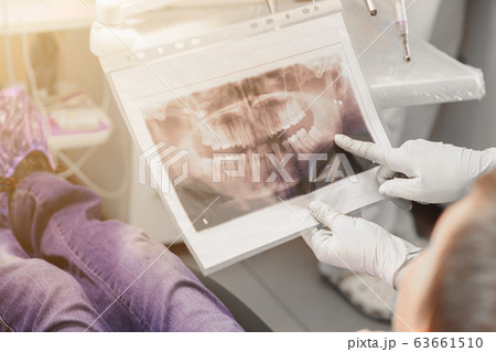 An orthodontist doctor shows the boy an x-ray of 63661510