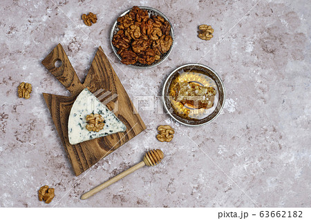blue cheese on wooden cutting board with honey and walnuts 63662182