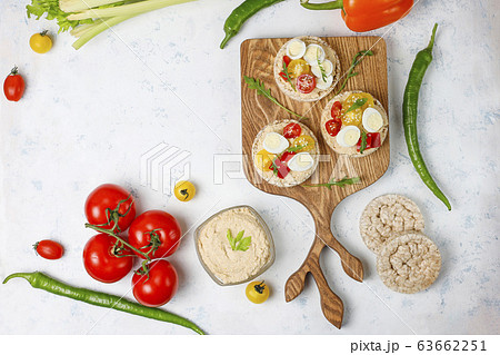 Open sandwiches of rice cakes with hummus , vegetables and quail egg, healthy breakfast or lunch Open sandwiches of rice cakes with hummus , vegetables and quail egg, healthy breakfast or lunch 63662251