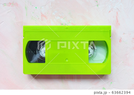 Green vintage VHS video tape on pink background 63662394