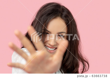 Beautiful brunette woman in a white blouse stretching her arm 63663738