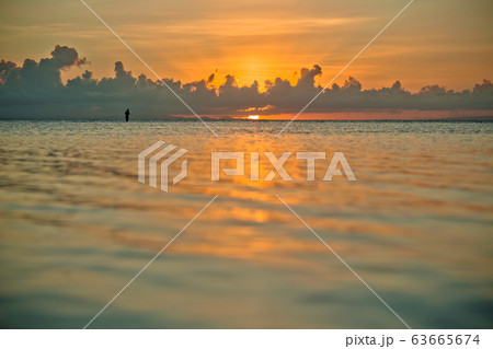 sunset and siluet of fisherman very far away 63665674