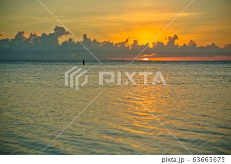 sunset and siluet of fisherman very far away 63665675