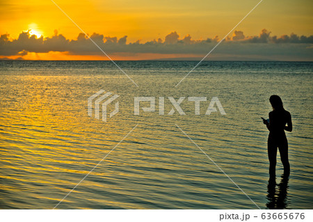 siluet of romantic girl reading a book during sunset 63665676