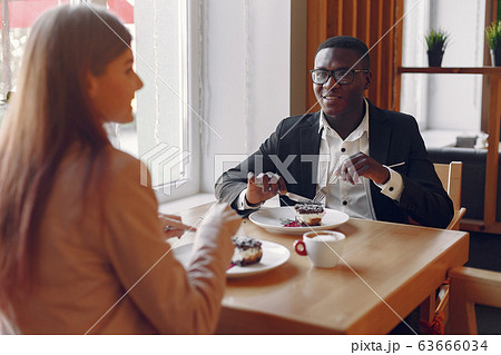 Internationals people sitting in a cafe and drinking a coffee Internationals people sitting in a cafe and drinking a coffee 63666034