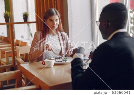 Internationals people sitting in a cafe and drinking a coffee 63666041