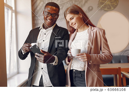 Internationals people standing in a cafe and drinking a coffee 63666108